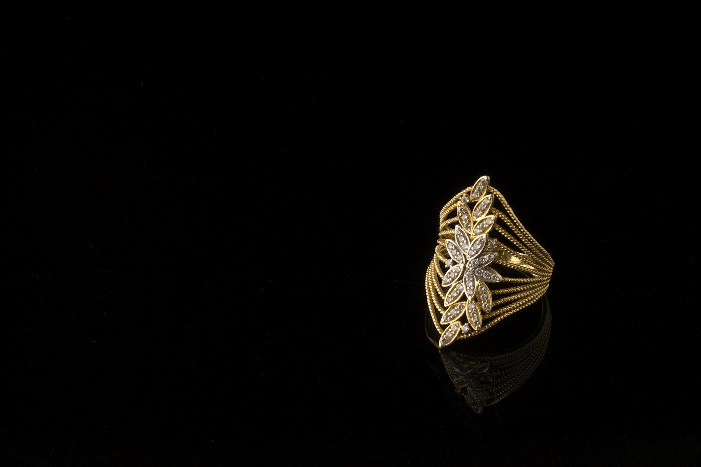 Ornate gold ring against a black background